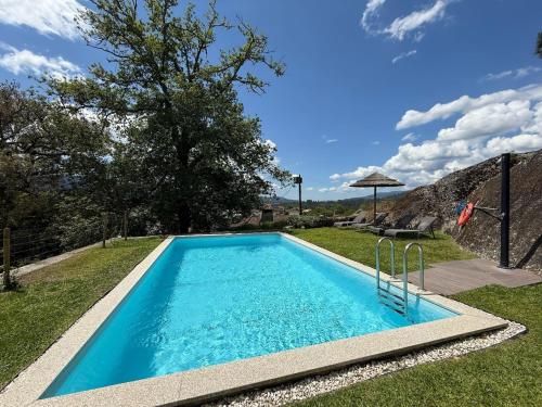 a swimming pool in the yard of a house at Quinta Encosta do Penedo - Wellness Retreat - Gerês in São Jorge