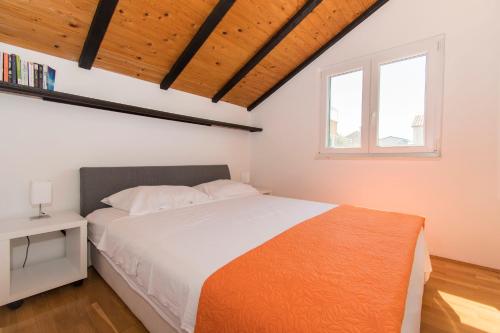 a bedroom with a white bed and a window at Apartments Njoko in Prvić Šepurine