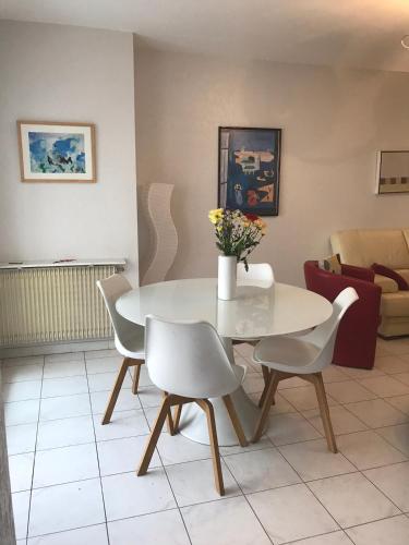 une table blanche et des chaises dans un salon dans l'établissement Spacious 2 BR 1 block from beaches - and the TRAM, à Nice