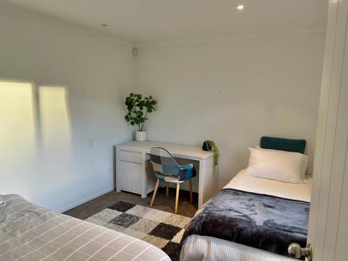 a bedroom with a desk and a bed and a chair at Cambridge Lodge in Cambridge