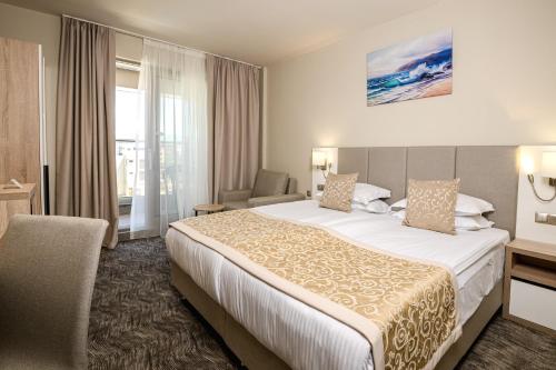 una habitación de hotel con una cama y una silla en Hotel Laguna Park Sunrise, en Sunny Beach