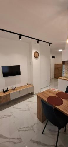 a living room with a table and a flat screen tv at Apartman Marija in Kladovo