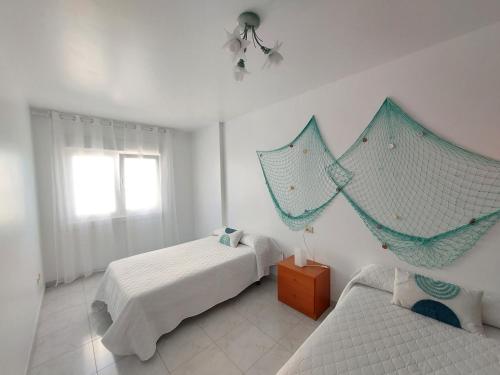 a bedroom with two beds with nets on the wall at Apartamento Buserán in Muxia