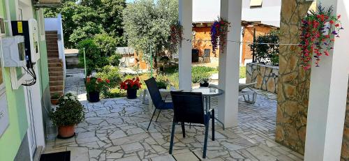 a patio with a table and chairs and flowers at Ema & Sea Apartment's in Pula
