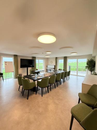 a conference room with a long table and chairs at Alp Art Hotel Monthey in Collombey