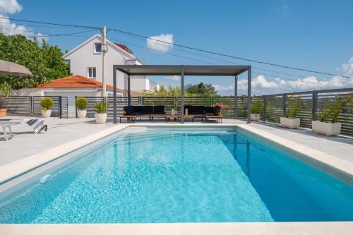 a swimming pool with a gazebo on a house at Villa Magnolia with heated Pool and Jacuzzi, near sea in Tugare