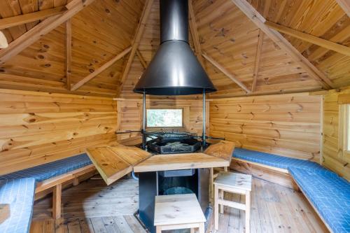 - une cuisine dans une cabane en rondins avec cuisinière dans l'établissement Grand Kota Avec Bain Nordique, à Saint-Cybranet