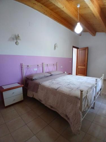 a bedroom with a large bed and a wooden ceiling at Le stanze di NinFa in Pacentro