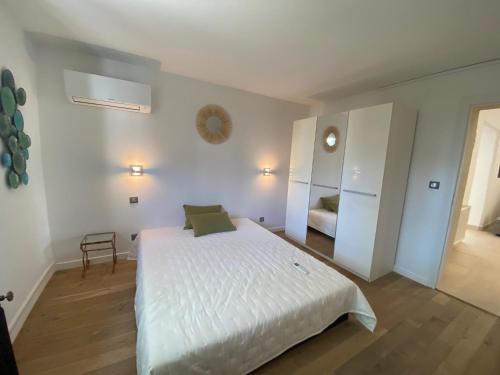 une chambre blanche avec un lit et une chaise dans l'établissement Villa avec piscine et salle de sport, à Castries