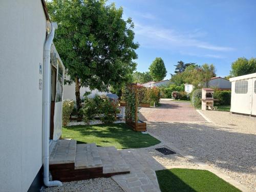une passerelle à côté d'une maison avec une cour dans l'établissement 2 stars - Dans Résidence de Loisirs, à Saint-Pierre-dʼOléron
