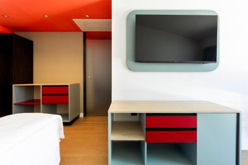 a living room with a tv on a wall at Sholeo Lodges Maspalomas in Playa del Ingles