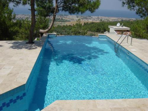 a large swimming pool with blue water at Samos View Villa in Kusadası