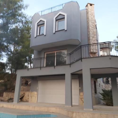 a house with a balcony and a pool at Samos View Villa in Kusadası