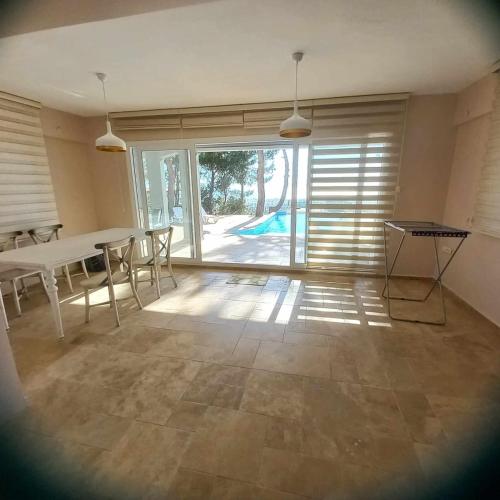 a dining room with a table and chairs and a large window at Samos View Villa in Kusadası