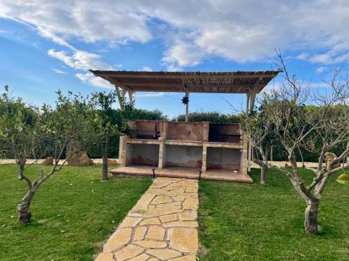 a pavilion in a garden with a stone path at Residenza alla Collina & Romantic SPA in Porto Conte