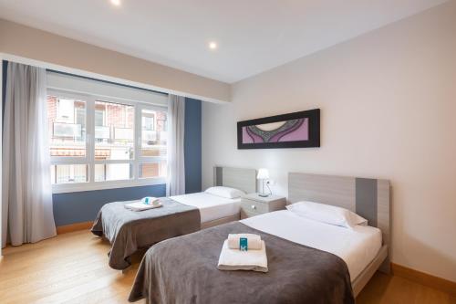 a hotel room with two beds and a window at Zerkausi - baskeyrentals in Tolosa