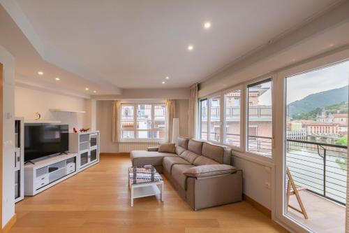 a living room with a couch and a television at Zerkausi - baskeyrentals in Tolosa