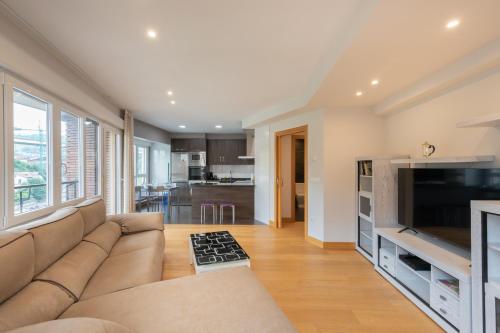 a living room with a couch and a television at Zerkausi - baskeyrentals in Tolosa