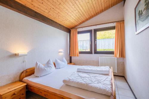 una camera da letto con un letto con due cuscini sopra di Ferienwohnpark Immenstaad am Bodensee Satteldachhaus Typ 9 SD 25 a Immenstaad am Bodensee