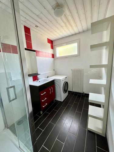 une salle de bain avec un lavabo et une machine à laver dans l'établissement Le Grand Air, à Bréville-sur-Mer