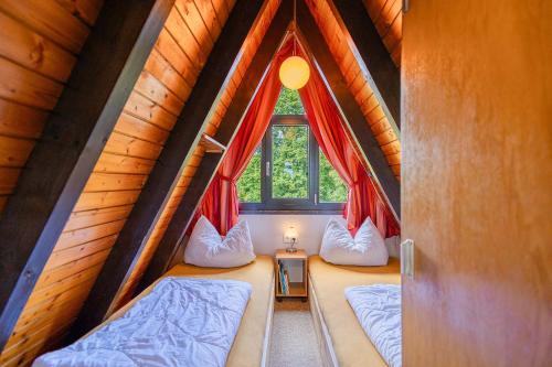 deux lits dans une chambre avec une fenêtre dans l'établissement Ferienwohnpark Immenstaad am Bodensee Nurdachhaus Typ 7 ND 50, à Immenstaad am Bodensee