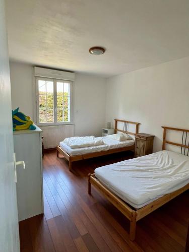 une chambre avec deux lits et une fenêtre dans l'établissement Le Grand Air, à Bréville-sur-Mer