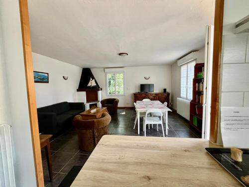 un salon avec une table et un canapé dans l'établissement Le Grand Air, à Bréville-sur-Mer