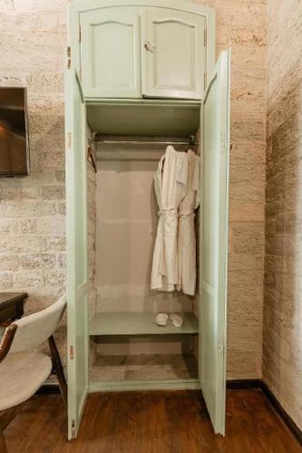 a walk in closet with white cabinets and towels at Royal Qala Hotel in Baku