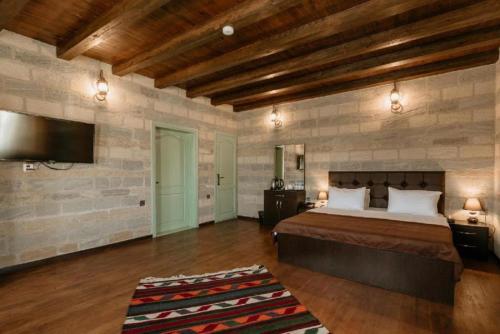 a bedroom with a bed and a flat screen tv at Royal Qala Hotel in Baku