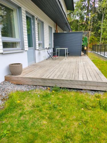a wooden deck in front of a house at Apartment & BBQ & free parking in Espoo