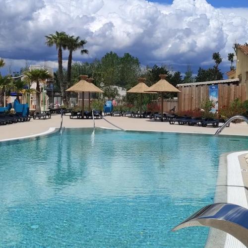 - une piscine d'eau bleue dans un complexe dans l'établissement Les Sables du Midi Mobil home Valras Plage, à Sérignan