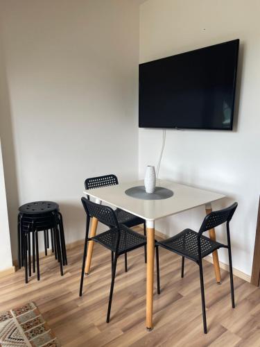 a table and chairs in a room with a tv at 7 people - 1 price - Cozy attic apartment in Prešov