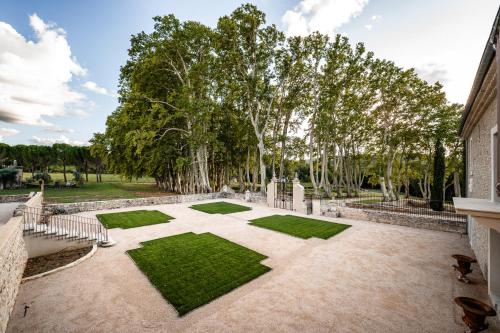 an image of a courtyard with trees and grass at Château de Taulignan in Saint-Marcellin-lès-Vaison