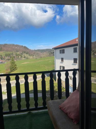 a balcony with a view of a building at Séjour calme et confortable in Métabief