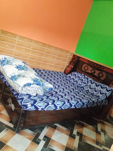 a bed in a room with a blue and white mattress at Rudraksha Homestay in Kharsālī