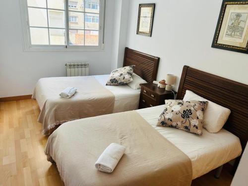 a bedroom with two beds and a window at Miguel Servet con GARAJE INCLUIDO in Zaragoza