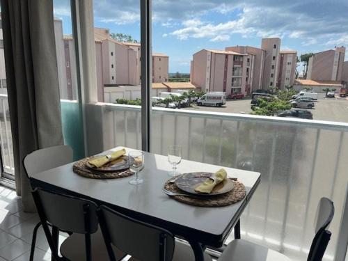 - une table avec deux assiettes de nourriture au-dessus d'un balcon dans l'établissement Appartement Rénové 5P à Agde - Parking, Piscine, Proche Plages et Commerces - FR-1-749-67, au Cap d'Agde