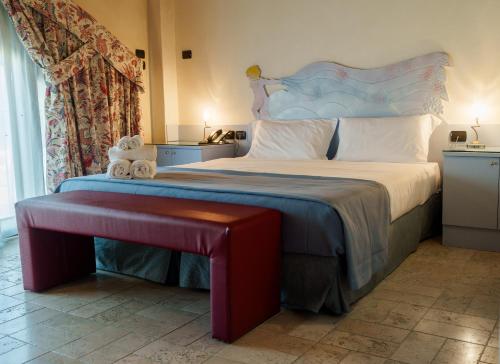 a bedroom with a large bed with a bench next to it at Villa Luisa Francesca in Montebelluna