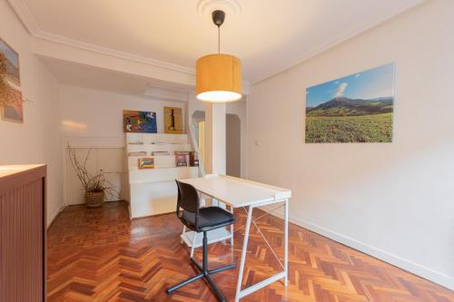 a white table and a chair in a room at Irie - baskeyrentals in Aretxabaleta
