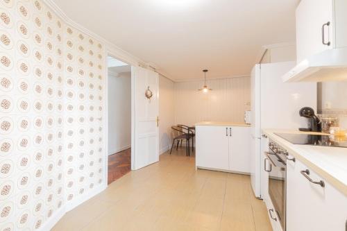 a kitchen with white cabinets and a dining room at Irie - baskeyrentals in Aretxabaleta