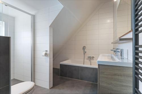 a bathroom with a tub and a sink at Oude Nieuwlandseweg 33 - Ouddorp - Villa Mastlo met 2 jacuzzi's - NOT FOR COMPANIES in Ouddorp