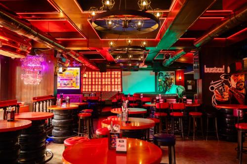 a restaurant with red tables and a green screen at Hotel Peninsula Redpine in Mumbai