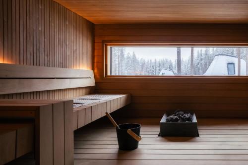 a sauna with a trash can and a window at Glass Resort in Rovaniemi