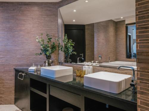 a bathroom with two sinks and a large mirror at Hotel de Mar Gran Meliá - Adults Only - The Leading Hotels of the World in Illetas