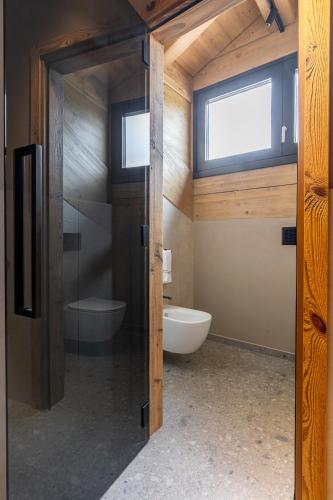 a bathroom with a tub and a toilet and a window at Paradise Lodge in Livigno