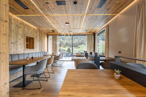 a restaurant with wooden ceilings and tables and chairs at Paradise Lodge in Livigno