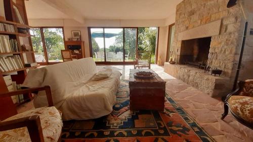 - un salon avec un canapé et une cheminée en pierre dans l'établissement La Villa d'Éole - Île aux moines, à l'Île-aux-Moines