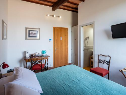 a bedroom with a bed and a table and a desk at Rooms and Wine al Castello in Monteriggioni