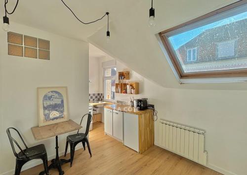 une cuisine avec une table et des chaises et une fenêtre dans l'établissement Appartement en hyper centre du Touquet, à Le Touquet-Paris-Plage