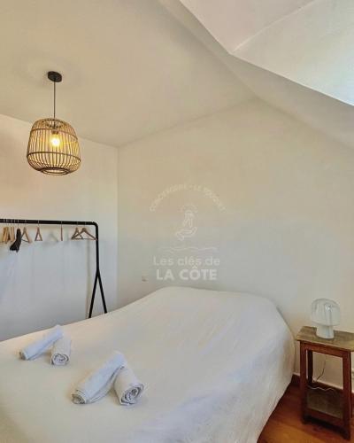 - une chambre avec un lit blanc et un lustre dans l'établissement Appartement en hyper centre du Touquet, à Le Touquet-Paris-Plage